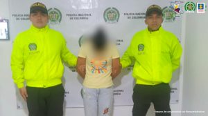 en la foto se aprecia a la hoy asegurada siendo custodiada por dos miembros de la Policía Nacional.