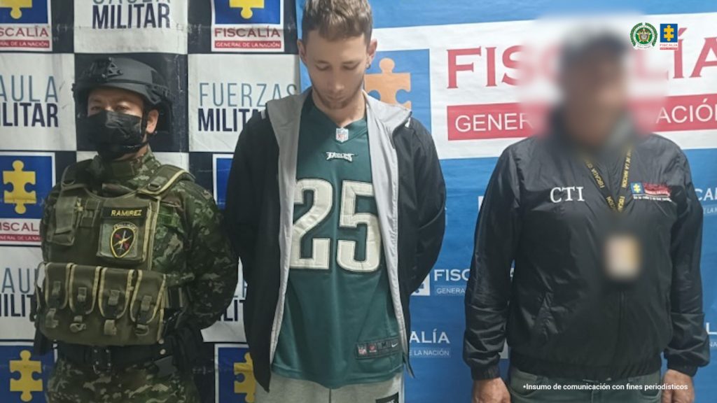 En la imagen se ve una persona detenida bajo custodia de un investigador del CTI y Gaula Ejército. Detrás suyo un backing institucional.