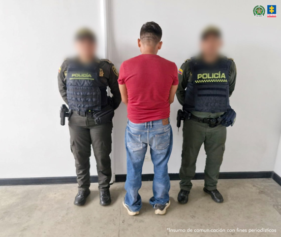 Se visualiza al capturado de espaldas, junto a dos uniformados de la Policía Nacional