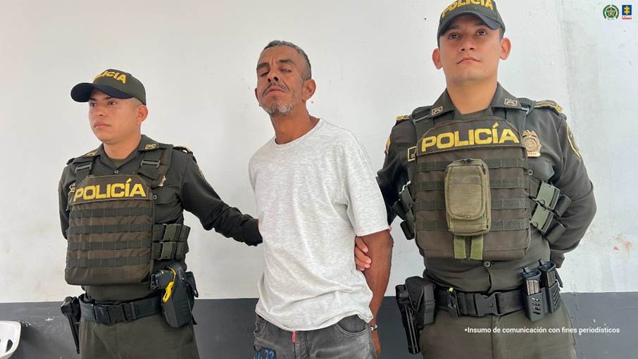 en la fotografia se puede observar al capturado esposado con las manos en la espalda, en medio de dos funcionarios de la policia