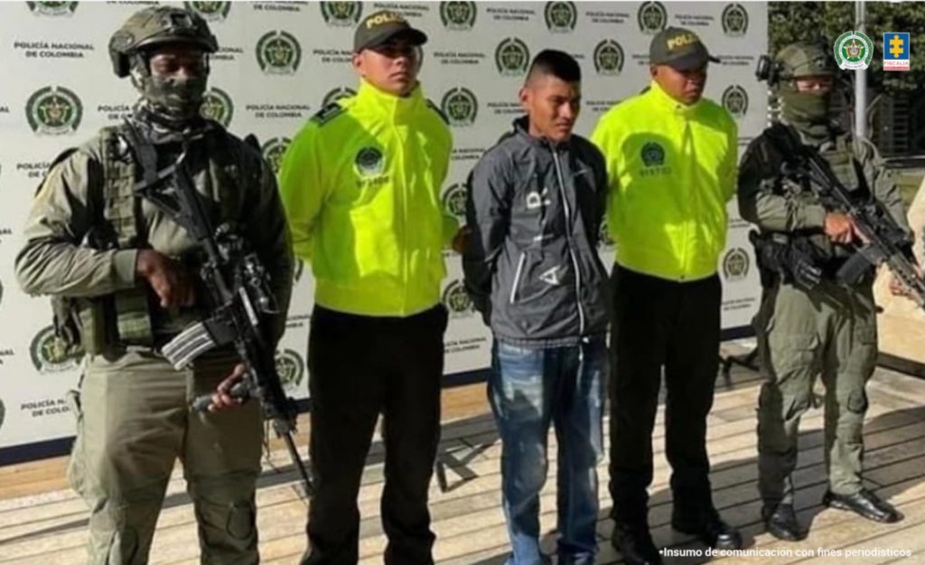 En la fotografía aparece el capturado junto a cuatro integrantes de la Policía. En la parte superior está un banner de la institución policial.