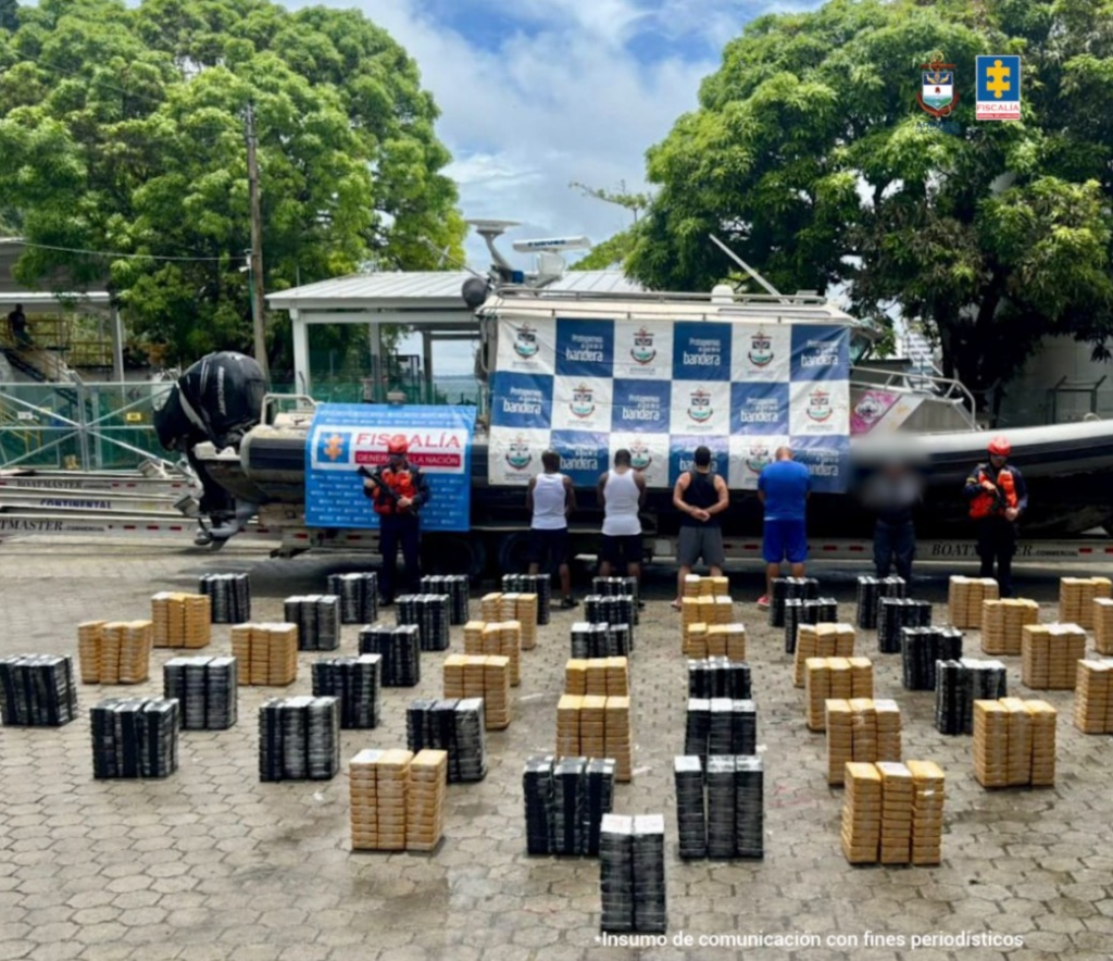 en la fotografía aparecen los cuatro imputados junto a dos infantes de la Armada Nacional. en la parte posterior está el cargamento de cocaína incautado