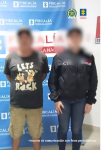 Se observa al capturado junto a investigador del CTI. Detrás el banner que identifica a la Fiscalía General de la Nación.