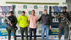  En la fotografía aparece el capturado junto a un funcionario del CTI y tres uniformados de la Policía Nacional. En la parte superior está un banner de la Policía Nacional.