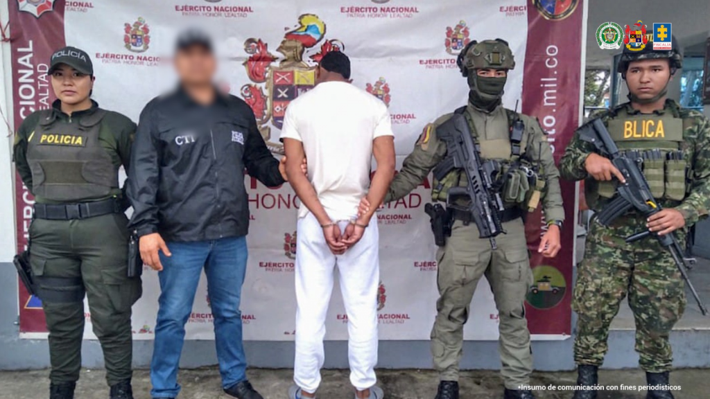 En la fotografía aparece el sentenciado junto a un servidor del CTI, dos integrantes de la Policía Nacional y un soldado del Ejército. En la parte superior está un banner del Ejército.