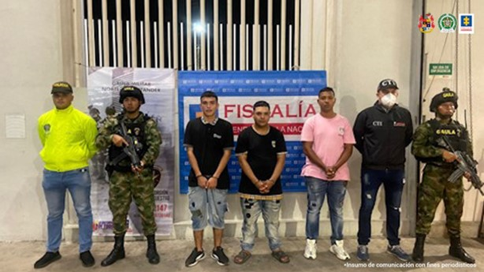 En la fotografía se aprecia a los tres capturados junto a un investigador del CTI y uniformados del Gaula Militar y Policía Nacional. En la parte posterior se aprecian los banners de la Fiscalía y del Gaula Militar.