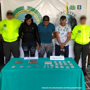 Se observa a los capturados junto a uniformados de la Policía Nacional. Frente a ellos una mesa con las sustancias alucinógenas incautadas. Detrás el banner que identifica a la Policía Nacional