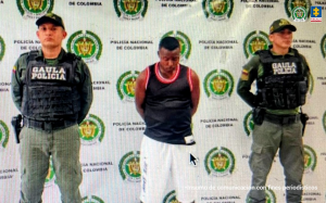 En la fotografía aparece el capturado junto a dos uniformados del Gaula de la Policía Nacional. En la parte superior está un banner de la Policía