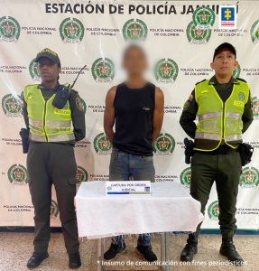 En la imagen se observa al capturado junto a dos uniformados de la Policía Nacional. En la parte posterior se observa el banner que identifica a la estación de Policía de Jamundí (Valle del Cauca)