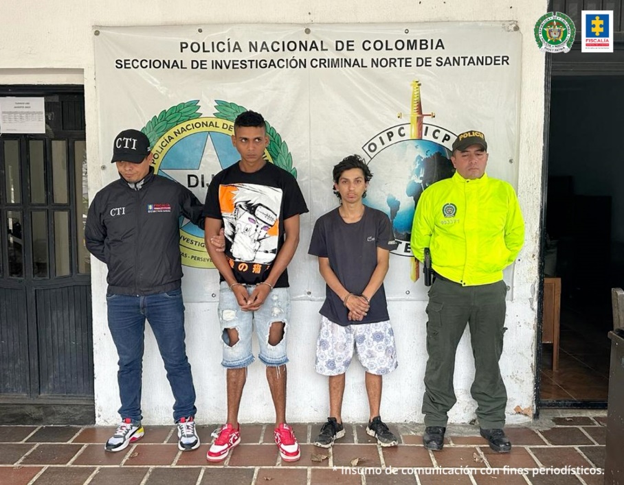 En la imagen se observa a los dos capturados junto a un investigador del CTI y uniformado de la Policía Nacional. Detrás de ellos se observa el banner que identifica a la Seccional de Investigación Criminal Norte de Santander de la Policía Nacional