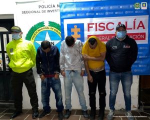 En la fotografía se aprecia a los capturados junto a un investigador del CTI y de la Sijin. En la parte posterior se observa los banners que identifican a la Fiscalía y la Policía Nacional