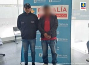 En la fotografía se aprecia al capturado junto a un investigador del CTI. En la parte posterior se observa el banner de la Fiscalía General de la Nación