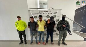En la imagen se observan a los tres capturados junto a uniformados de la Policía Nacional. En la parte posterior se aprecia el banner que identifica la Seccional de Investigación Criminal SIJIN.