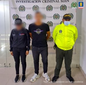 Se visualiza al capturado con el rostro difuminado junto a una investigadora del CTI y uniformado de la Policía Nacional. Detrás el banner que identifica a Sijín de la Policía Nacional.