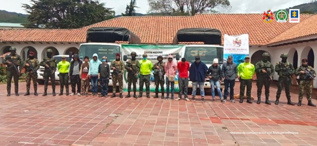 En la fotografía se aprecia a los 12 capturados junto a uniformados de la Policía y el Ejército Nacional. En la parte posterior un banner que identifica a la Policía Nacional.