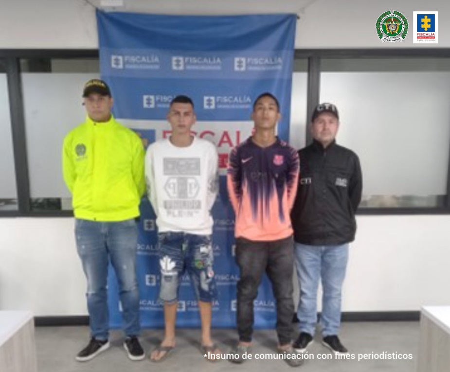 En la fotografía se observa a los dos capturados junto a investigadores del CTI y de la Sijin. En la parte posterior se aprecia el banner de que identifica a la Fiscalía General de la Nación