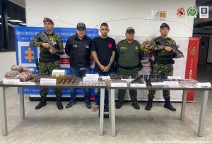 En la imagen aparece el capturado junto a investigador del CTI y uniformados del Ejército y Policía Nacional. Frente a ellos dos mesas con las sustancias incautadas entre ellas 78 ampolletas de Fentanilo. Detrás de ellos los banners que identifican a la Fiscalía General de la Nación y al Ejército Nacional.