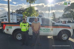 En la imagen se aprecia al capturado junto a un uniformado de la Policía Nacional. Detrás una camioneta con logos de la Policía Nacional.