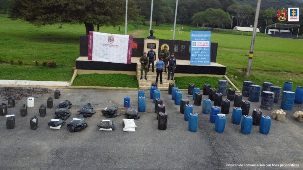 En la fotografía aparece el capturado de espaldas junto a uniformados del Ejército Nacional e investigadores del CTI. Frente a ellos la sustancia incautada en bolsas y canecas de plástico.