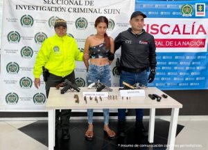 Fiscal Martha Mancera, Martha Mancera, Fiscal Mancera Se visualiza a la captura en medio de un uniformado de la Policía Nacional e investigador del CTI. Al frente una mesa con el material incautado (armas y municiones). En la parte posterior los banners institucionales que identifican a la Policía Nacional y Fiscalía General de la Nación.