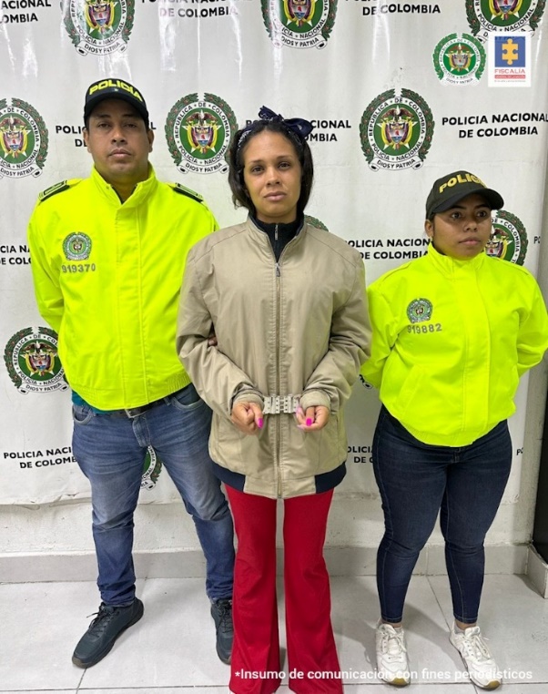 En la imagen se aprecia a la capturada junto a dos uniformados de la Policía Nacional. Detrás de ellos el banner que identifica a la Policía Nacional