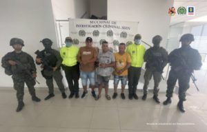 En la imagen se observa a los tres capturados junto a uniformados de la Policía y Ejército Nacional. Detrás de ellos se encuentra el banner que identifica a la Policía Nacional