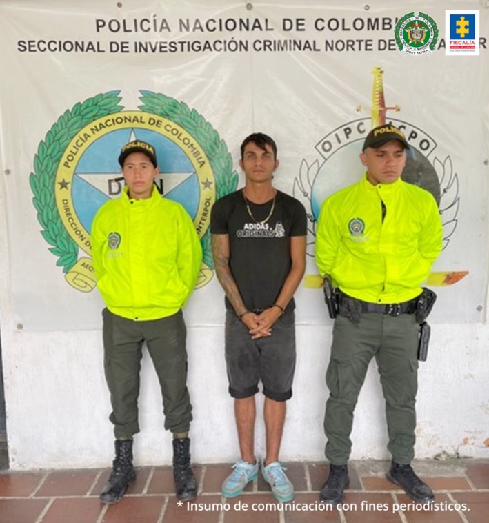 En la imagen se observa al capturado junto a dos uniformados de la Policía Nacional. En la parte posterior se observa el banner que identifica a la Seccional de Investigación Criminal Norte de Santander de la Policía Nacional
