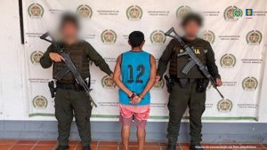 Se visualiza al capturado de espaldas junto a dos uniformados de la Policía Nacional.