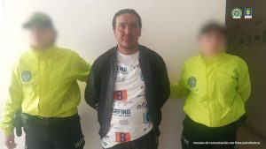 Se visualiza al capturado junto a dos uniformados de la Policía Nacional.