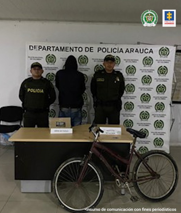 En la fotografía se observa el capturado de espaldas junto a dos uniformados de la Policía Nacional; frente a ellos se encuentra los elementos hurtados y la bicicleta incautada. En la parte posterior se aprecia el banner de la Policía Nacional.