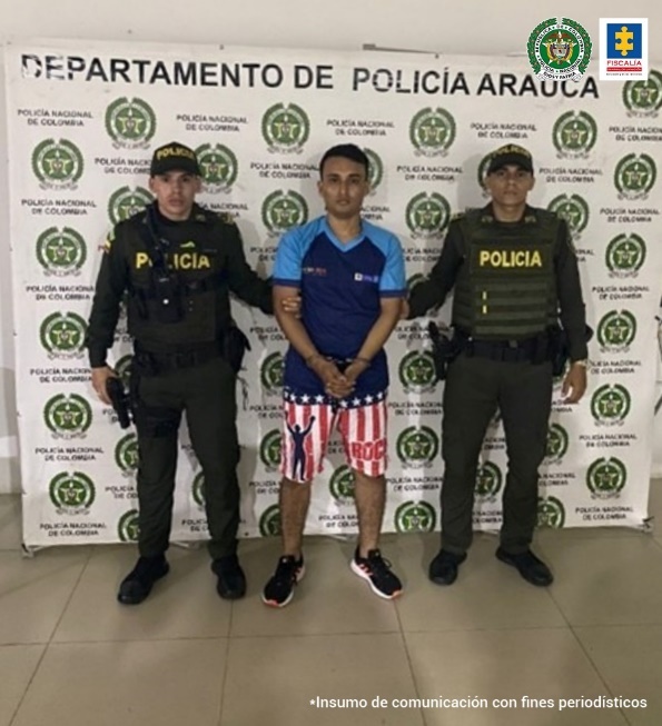 En la fotografía se aprecia al capturado junto a dos uniformados de la Policía Nacional. En la parte posterior se observa el banner que identifica a la Policía Nacional.