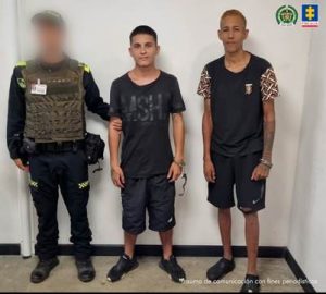 Se visualiza a los dos capturados junto a un uniformado de la Policía Nacional.