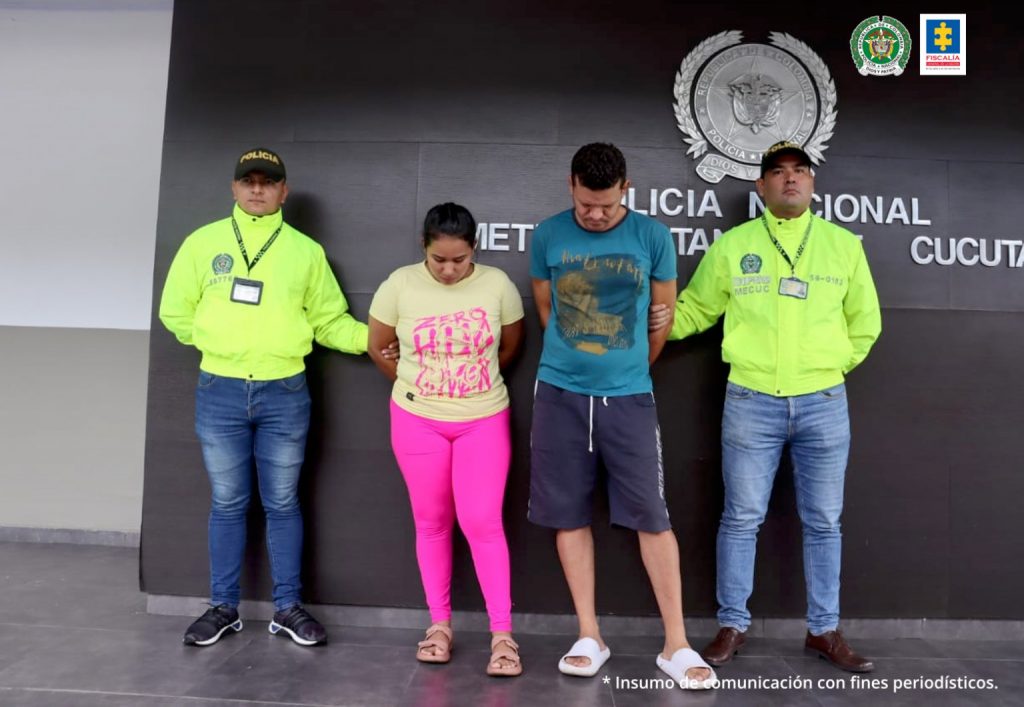 En la gráfica aparece la pareja de esposos, junto a uniformados de la Policía Nacional. Detrás se observa un banner que identifica a la Policía Metropolitana de Cúcuta