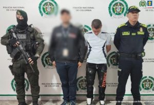 En la imagen se ve una persona detenida bajo custodia de un investigador del CTI y un uniformado de la Policía Nacional.