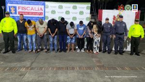 en la imagen se ven varias personas detenidas bajo custodia de integrantes del CTI y la Policía Nacional. Detrás suyo, backings institucionales.