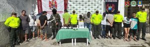  En la imagen se ven varias personas detenidas bajo custodia de servidores de la Policía y el Ejército. 