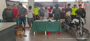 En la imagen se ven varias personas detenidas bajo custodia de integrantes de la Policía Nacional, Fuerza Aérea y Ejército. Detrás suyo, backings institucionales.