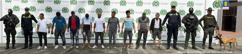 en la imagen se ve un grupo de personas detenidas bajo custodia de uniformados de la Policía Nacional.