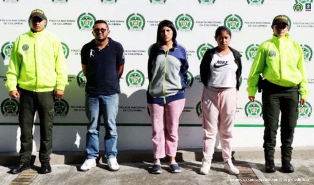 En la imagen se ven tres personas detenidas bajo custodia de la Policía Nacional.