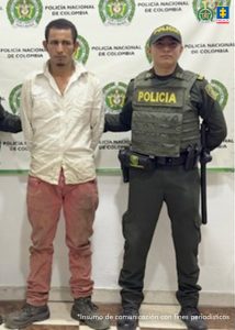 en la imagen se ve una persona detenida bajo custodia de dos uniformados de la Policía Nacional.