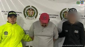 En la imagen se ve una persona detenida bajo custodia de un integrante del CTI de la Fiscalía y de un Policía.