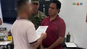 En la imagen se ve una persona detenida bajo custodia de integrantes del Ejército Nacional. Detrás suyo un backing institucional.