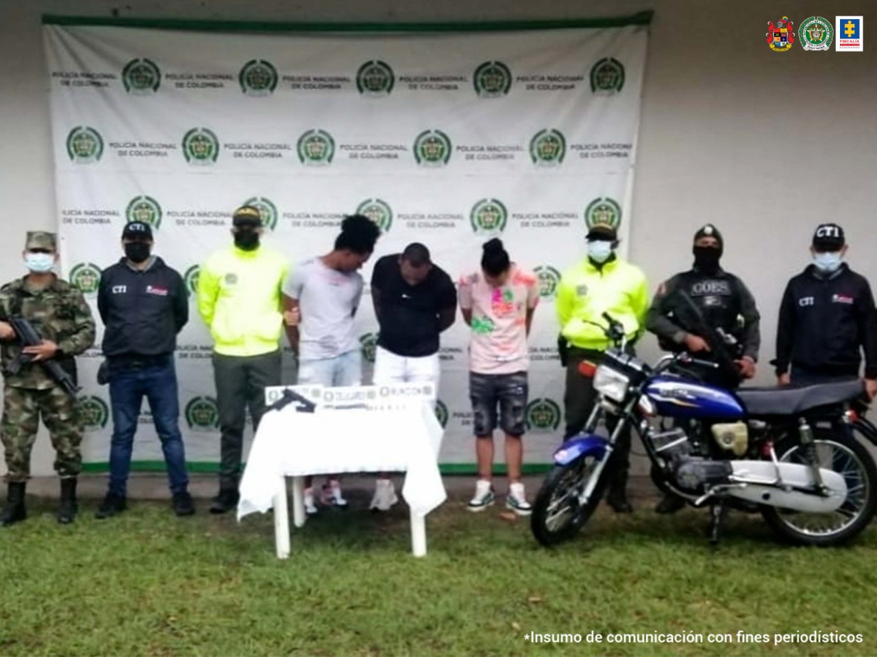 En la fotografía se observan los tres capturados junto a dos servidores del CTI, dos unidades del Goes, un agente de la Sijin de la Policía Valle y un soldado del Ejército. En la parte posterior se observa una mesa con un arma de fuego, munición, tres teléfonos celulares y una motocicleta