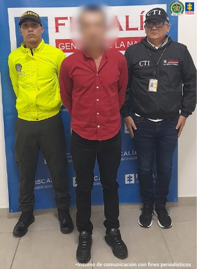 en la imagen se ve una persona detenida bajo custodia de un servidor del CTI de la Fiscalia y un integrante de la Policía Nacional.