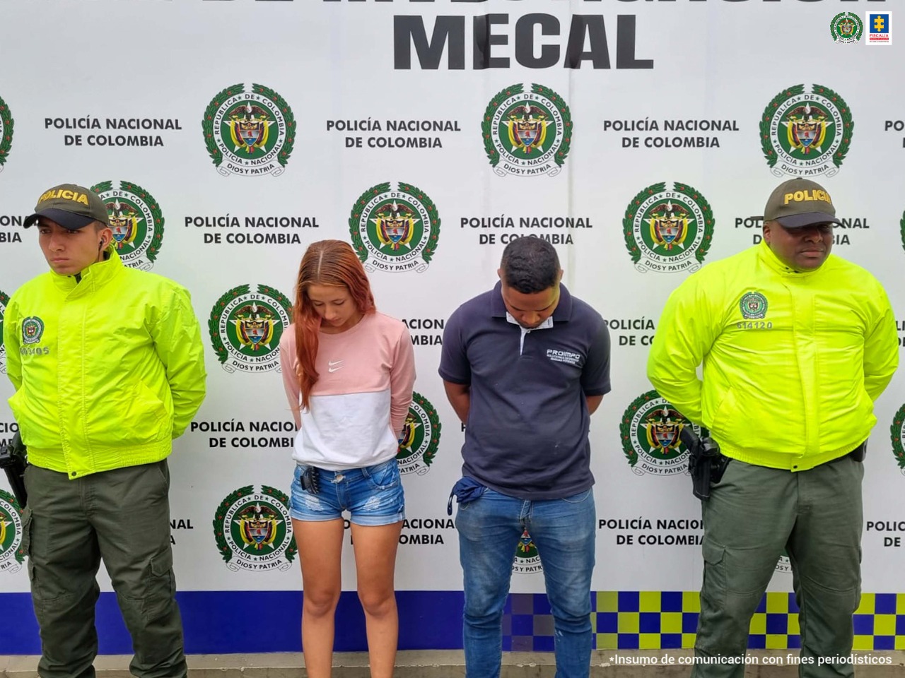 En la fotografía se observa a la pareja junto a dos agentes de la Policía Metropolitana, Mecal. En la parte superior, se observa un banner de la Policía Nacional