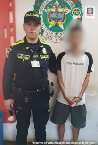 En la fotografía aparece el capturado junto a un agente de la Policía Nacional. En la parte superior se observa un banner de la Policía Nacional 