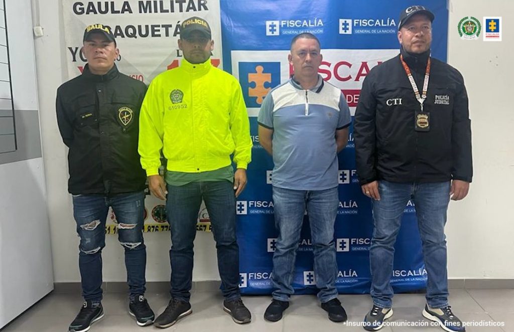 n la imagen se ven miembros del CTI de la Fiscalía, Policía Nacional y Gaula Militar con un detenido. Detrás suyo, un backing alusivo a la Fiscalía General de la Nación y de Gaula Militar de Caquetá.