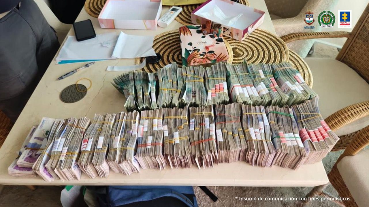 Pueden verse varios fajos de billetes sobre una mesa.