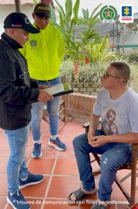en la imagen se ve una persona sentada a quien investigadores del CTI y la Ponal le leen sus derechos como capturado.