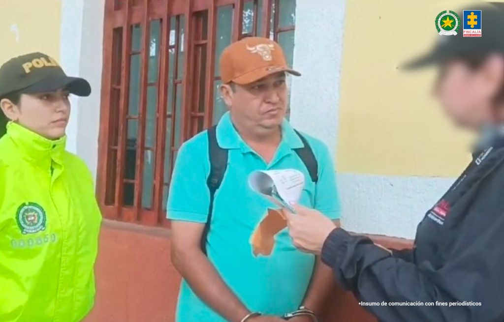 Fotografia del momento en donde al capturado le leen sus derechos dos agentes de policia